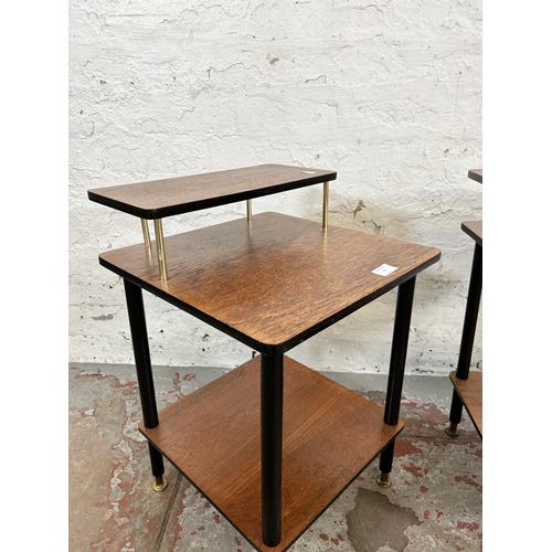 7 - A pair of mid 20th century teak and black painted two tier side tables