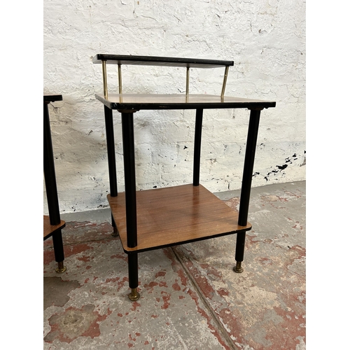 7 - A pair of mid 20th century teak and black painted two tier side tables