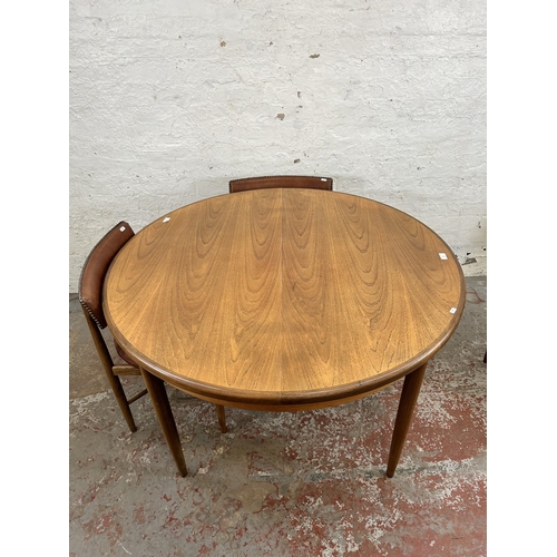 70 - A 1960s G Plan Fresco teak circular extending dining table and four dining chairs