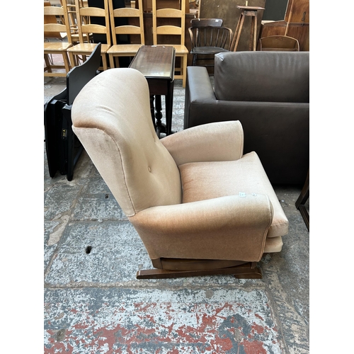 72 - A mid 20th century fabric upholstered and beech rocking armchair