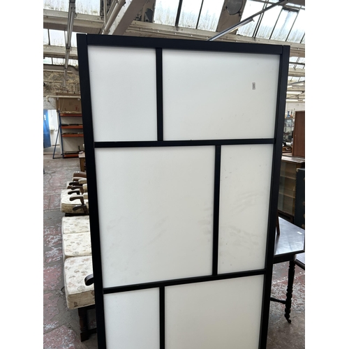 74 - An Oriental style white plastic and black ash effect three section folding dressing screen