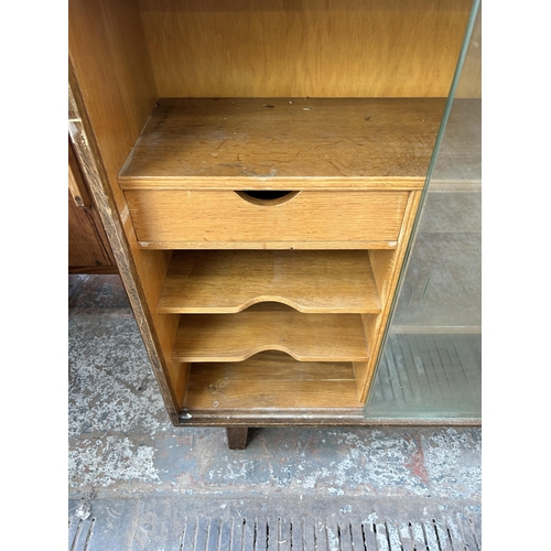 95 - A mid 20th century oak bookcase with two glass sliding doors and fitted interior