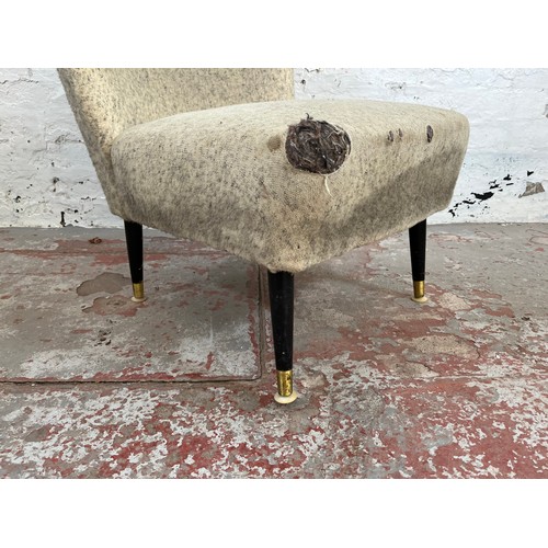 83 - A mid 20th century fabric upholstered lounge chair with black painted and brass splayed supports