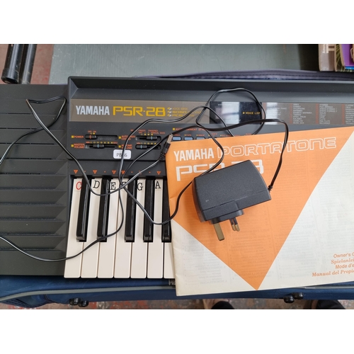 544 - A Yamaha PSR-28 electronic keyboard with stand, power adaptor and a collection of books