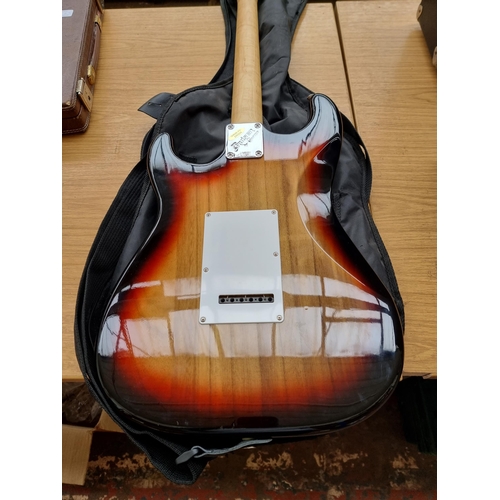 549 - A cased Crafter Cruiser sunburst Stratocaster style electric guitar with strap, pitch pipe and tremo... 