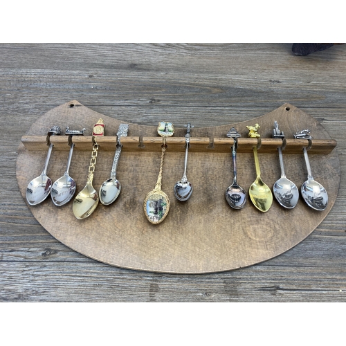 313 - A large collection of white metal collector's spoons and four hardwood wall mountable display plaque... 