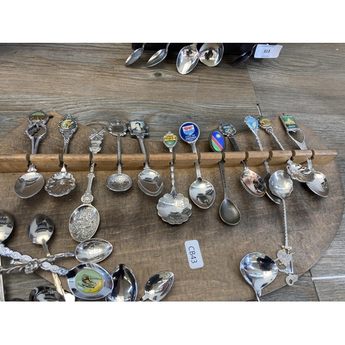 313 - A large collection of white metal collector's spoons and four hardwood wall mountable display plaque... 