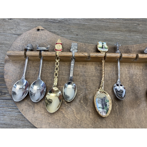 313 - A large collection of white metal collector's spoons and four hardwood wall mountable display plaque... 