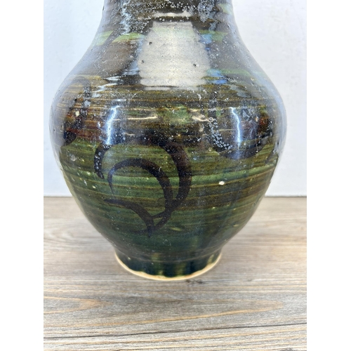 195 - A mid 20th century green glazed studio pottery vase marked 'BA' to base - approx. 27cm high