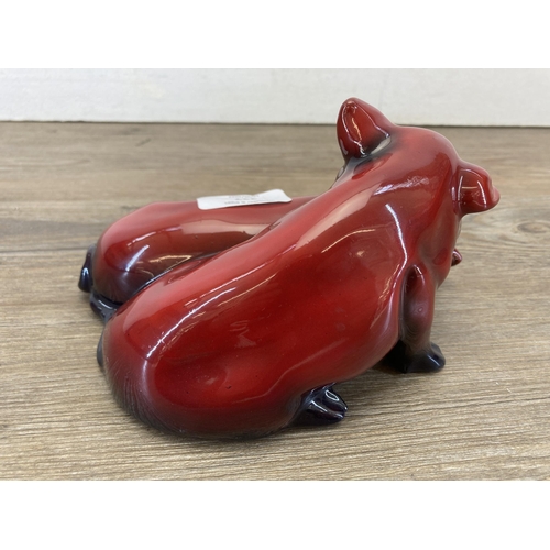 227 - A Royal Doulton Flambé Snoozing Pigs figurine signed 'Noke' - approx. 18cm long