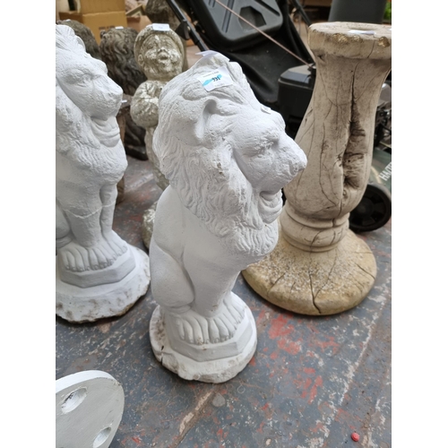 715 - A pair of white painted cast stone seated lion garden ornaments