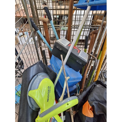 721 - A large collection of garden tools to include, garden groom midi, shovels, rakes etc. (cage not incl... 