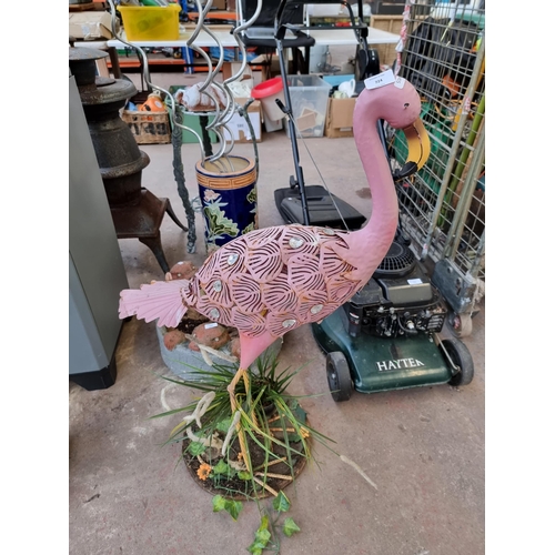 724 - A collection of garden items to include metal flamingo, cast stone bird bath in the form of two otte... 