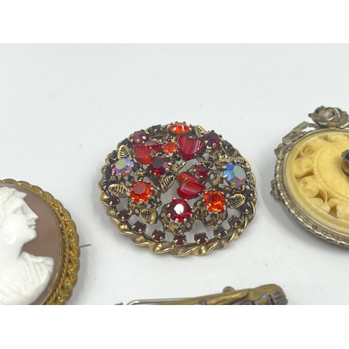 1192 - Five antique and vintage brooches to include novelty horn compass, ivory effect circular floral stam... 