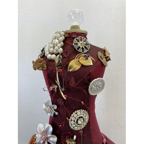 408 - A mannequin with seventeen vintage brooches