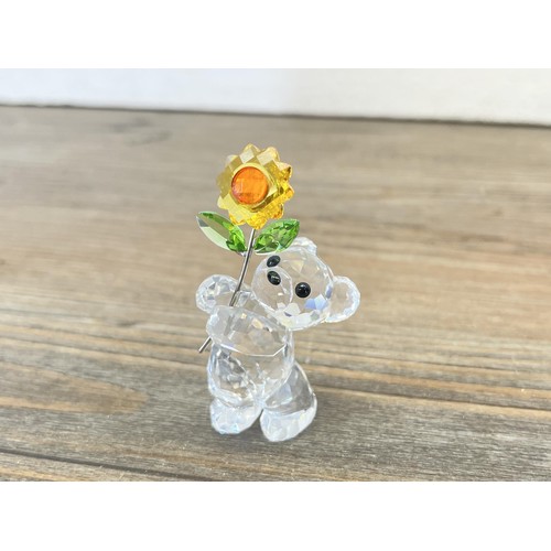 208 - A boxed Swarovski Crystal teddy bear with flower figurine - approx. 6cm high