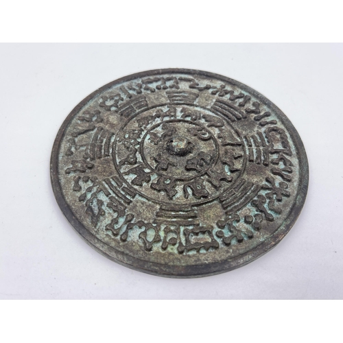 1353 - Two Chinese items, one carved ice jade amulet and one bronze Zodiac mirror - approx. 12cm diameter