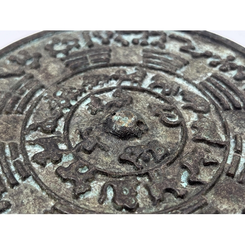 1353 - Two Chinese items, one carved ice jade amulet and one bronze Zodiac mirror - approx. 12cm diameter