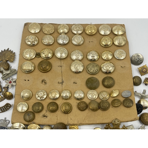 1387 - A collection of military buttons and cap badges to include The Royal Highlanders Blackwatch, Royal E... 