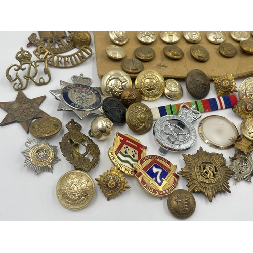 1387 - A collection of military buttons and cap badges to include The Royal Highlanders Blackwatch, Royal E... 