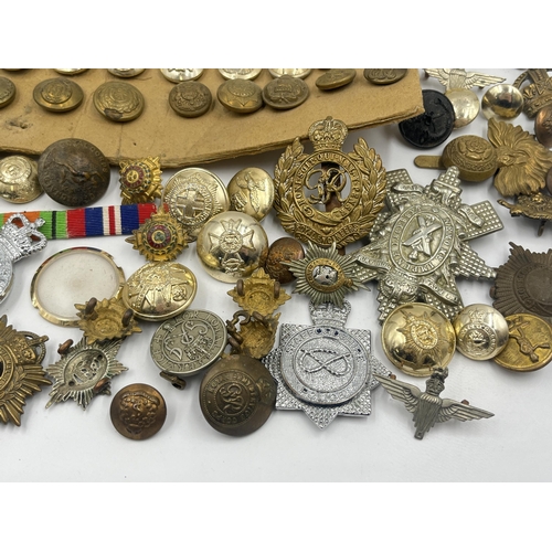 1387 - A collection of military buttons and cap badges to include The Royal Highlanders Blackwatch, Royal E... 