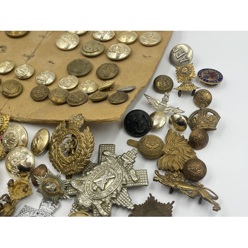 1387 - A collection of military buttons and cap badges to include The Royal Highlanders Blackwatch, Royal E... 