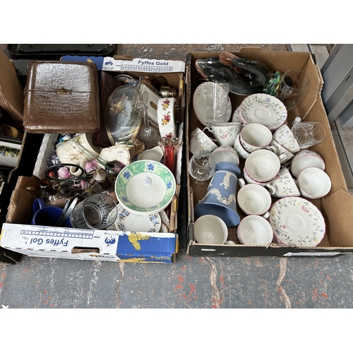 791 - Nine boxes containing lamps, vintage tennis racket, tambourine, glassware, cased cutlery and ceramic... 