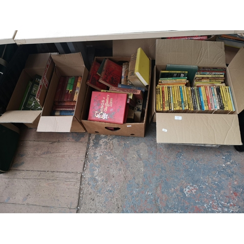 775 - Four boxes containing books to include a large collection of John Creasey paperbacks, Cricket books ... 