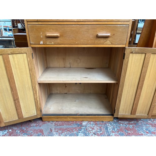 109 - A 1940s oak tall boy with two drawers and two cupboard doors - approx. 123cm high x 83.5cm wide x 47... 