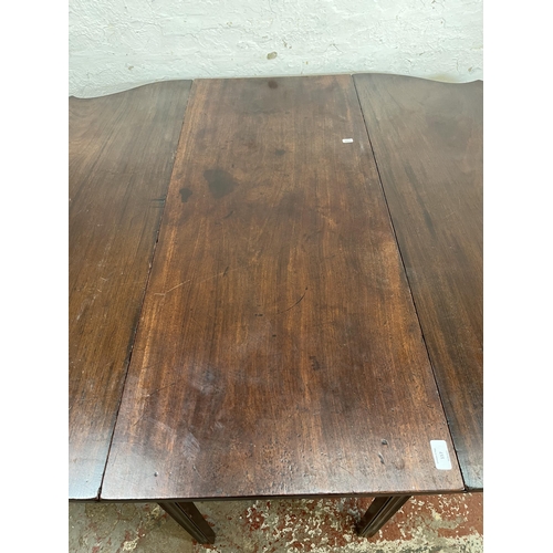 15 - A George II mahogany drop leaf gate leg serpentine dining table