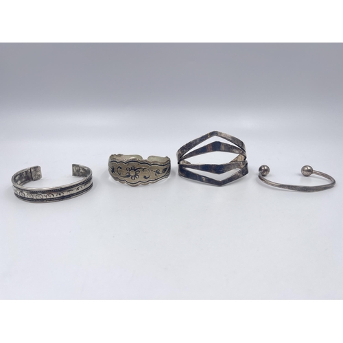 1209 - Four cuff bracelets to include two tested silver, Latvian silver etc.