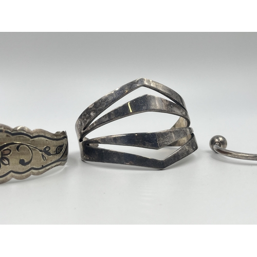 1209 - Four cuff bracelets to include two tested silver, Latvian silver etc.