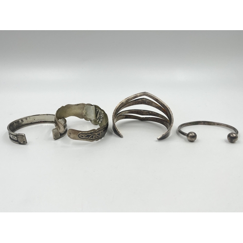 1209 - Four cuff bracelets to include two tested silver, Latvian silver etc.