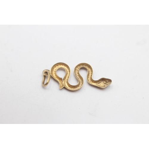 1090 - A 9ct gold textured snake pendant charm - approx. gross weight 0.3 grams