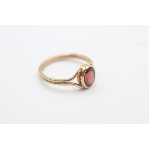 1150 - A 9ct gold oval garnet split shank solitaire ring - approx. gross weight 2.1 grams