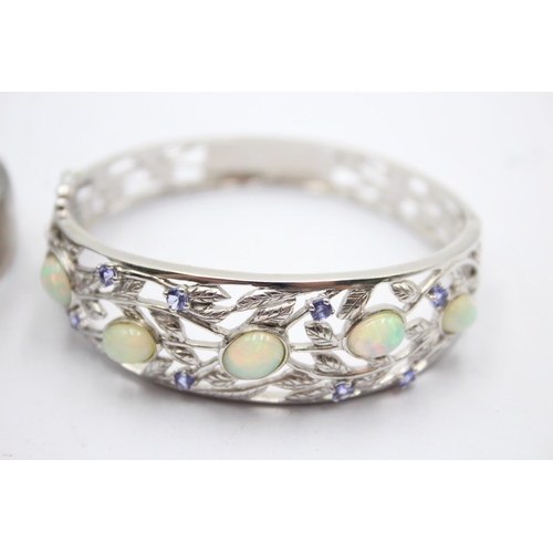 1175 - Two .925 silver gemstone set bangles, one opal and tanzanite and one amethyst - approx. gross weight... 