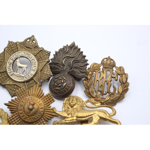 1396 - Ten military cap badges to include R.F.C, Canadian, Irish etc.