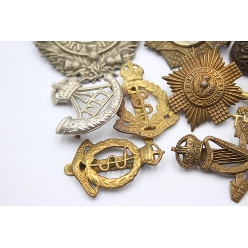 1396 - Ten military cap badges to include R.F.C, Canadian, Irish etc.