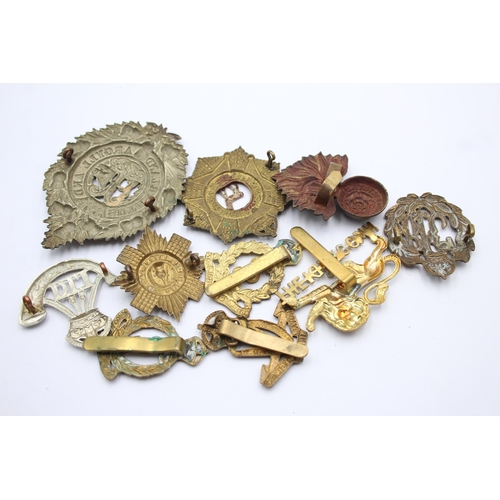 1396 - Ten military cap badges to include R.F.C, Canadian, Irish etc.