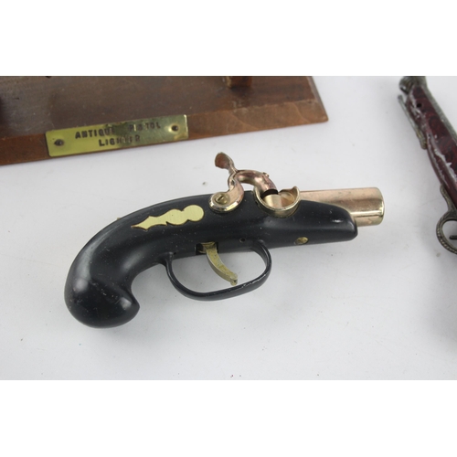 1409 - Three vintage novelty gun shaped cigarette/table lighters