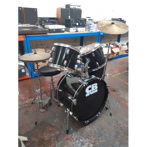 822A - A black CB Drums five piece drum kit comprising bass drum, floor tom, two rack toms, snare on stand,... 