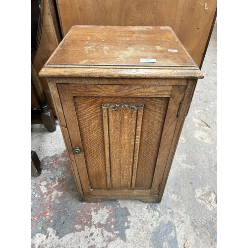 130 - A mid 20th century oak linenfold bedside cabinet