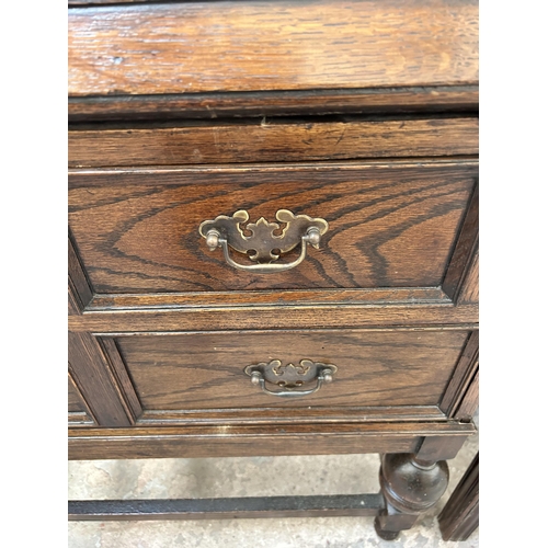 16 - A 1930s oak bureau with two drawers, fall front and baluster supports