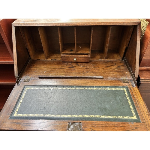 16 - A 1930s oak bureau with two drawers, fall front and baluster supports