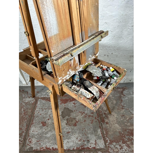 20 - A beech artist's easel containing Daler-Rowney oil paints