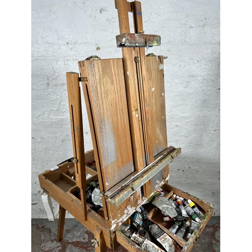 20 - A beech artist's easel containing Daler-Rowney oil paints