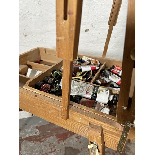 20 - A beech artist's easel containing Daler-Rowney oil paints