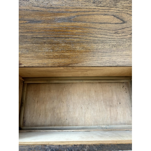 3 - An oak blanket box with carved front and baluster supports