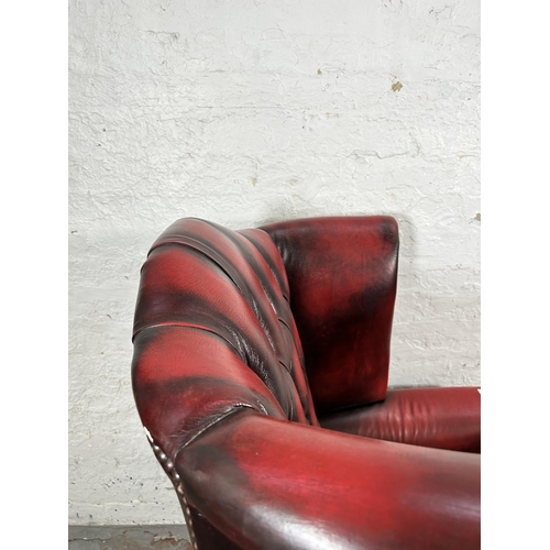 33 - An oxblood leather Chesterfield wingback armchair with cabriole supports