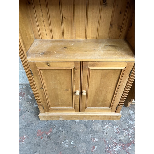 37 - A pine bookcase with three upper shelves and two lower cupboard doors